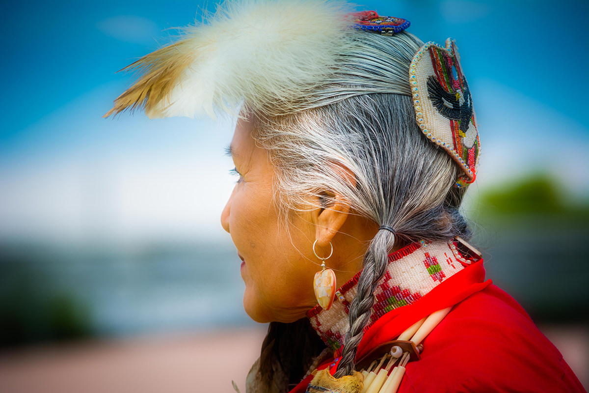 Profile of elegant Lady Pow Wow dancer at an event in Mesa, Arizona on 4.1.2017, Native American woman, Orton effect on feather, stylized portrait
